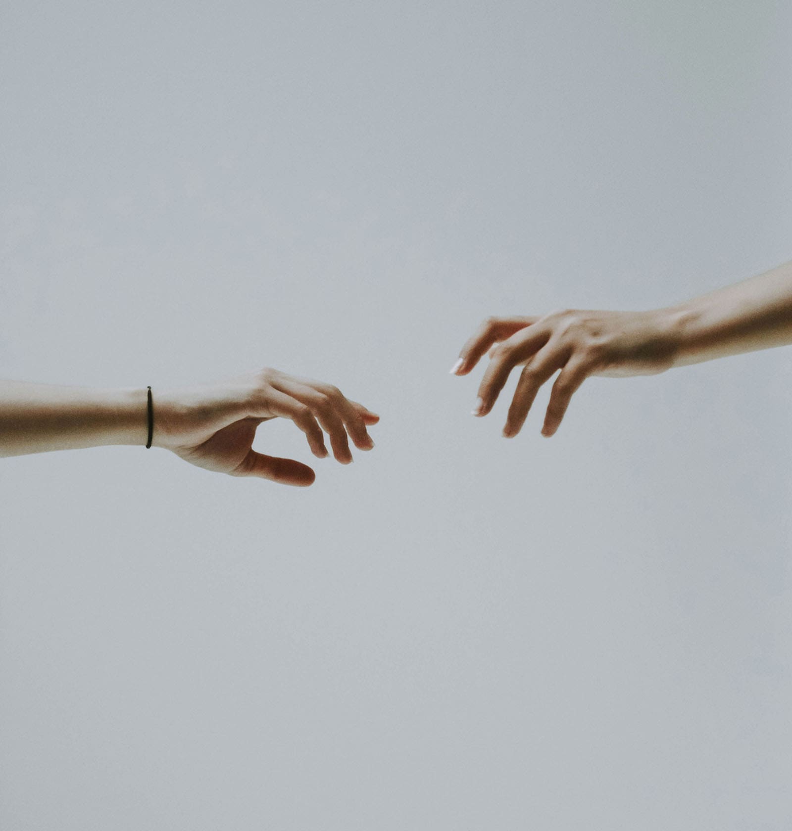 Two hands reaching toward each other