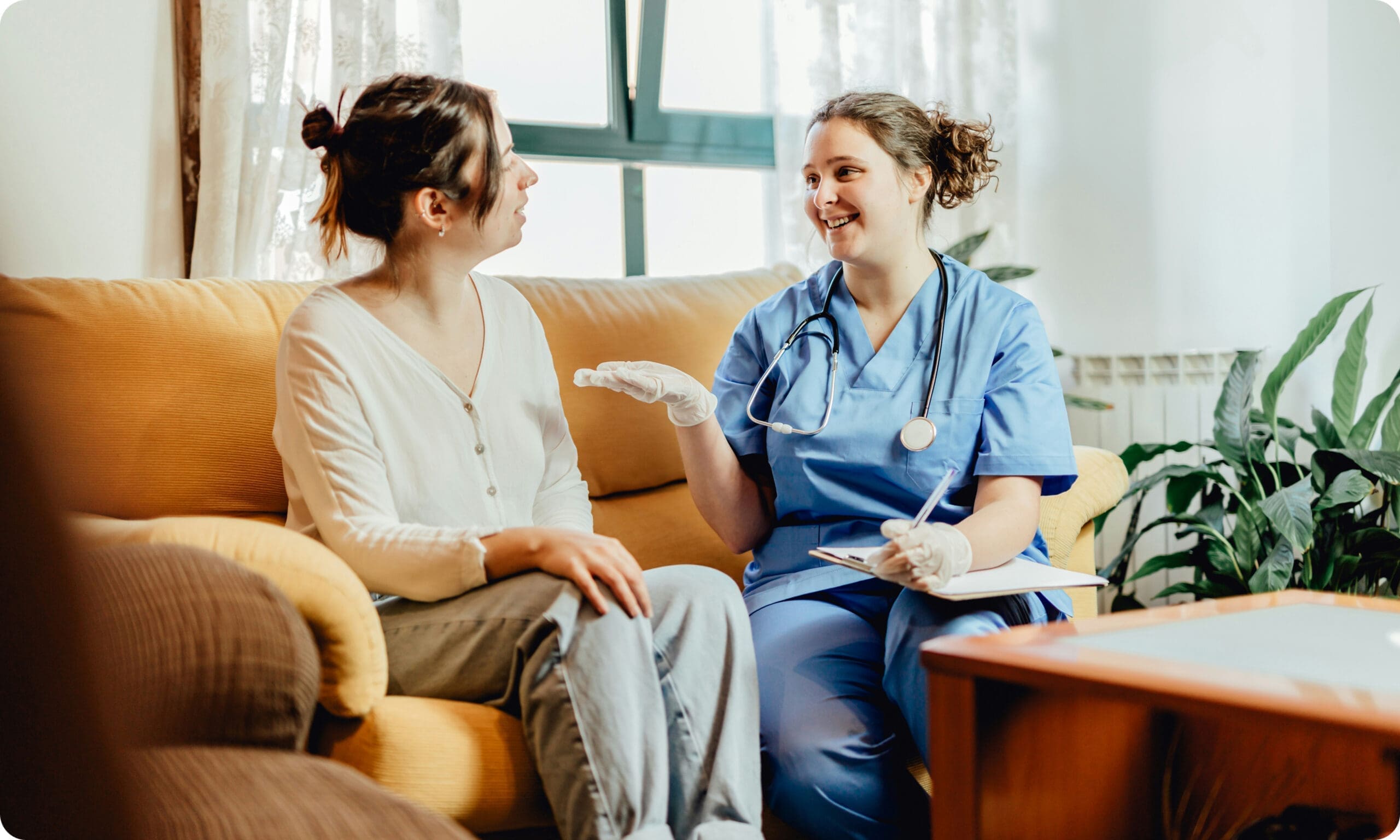 Healthcare worker speaking with patient during home visit