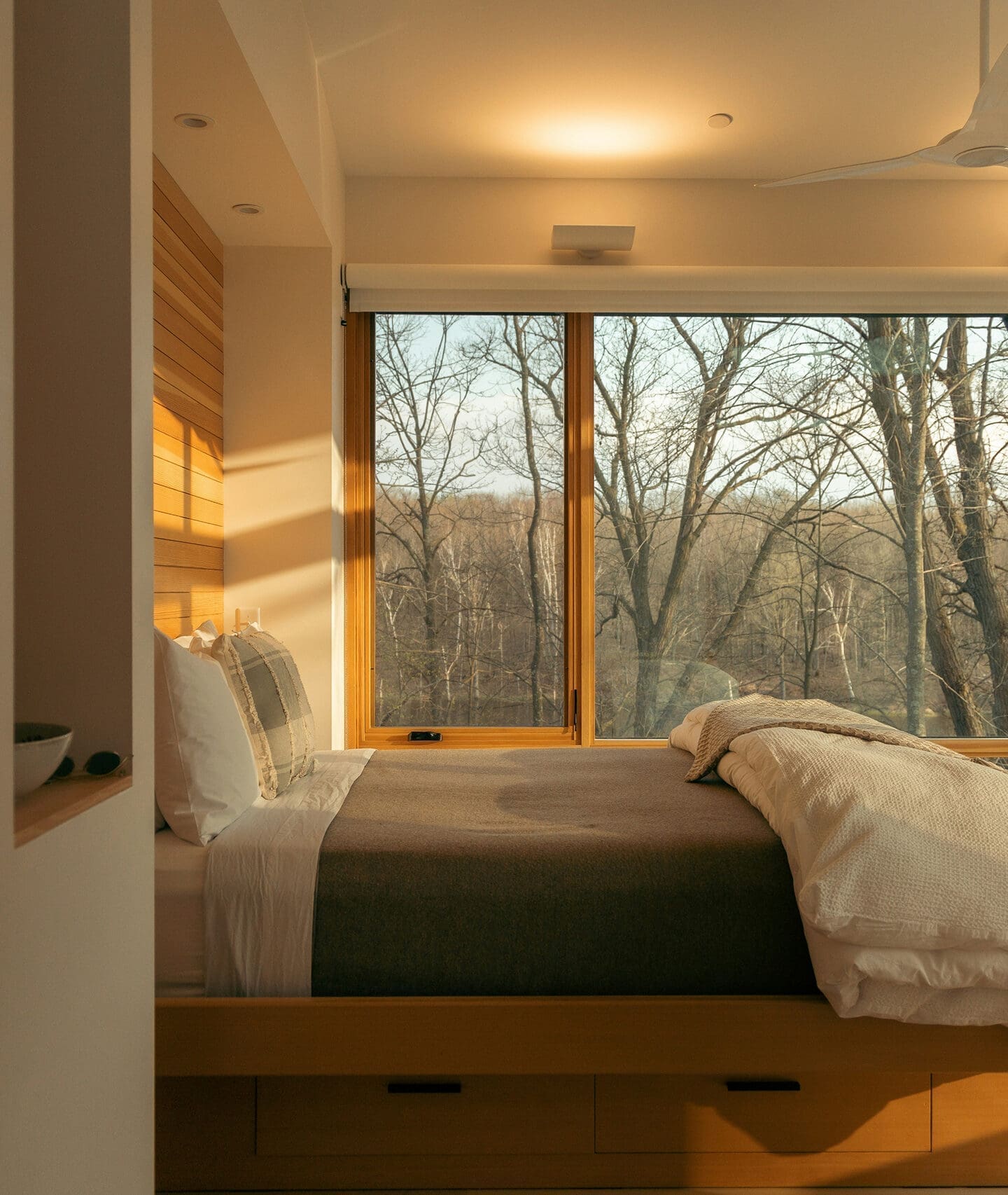 Bedroom with large window overlooking trees