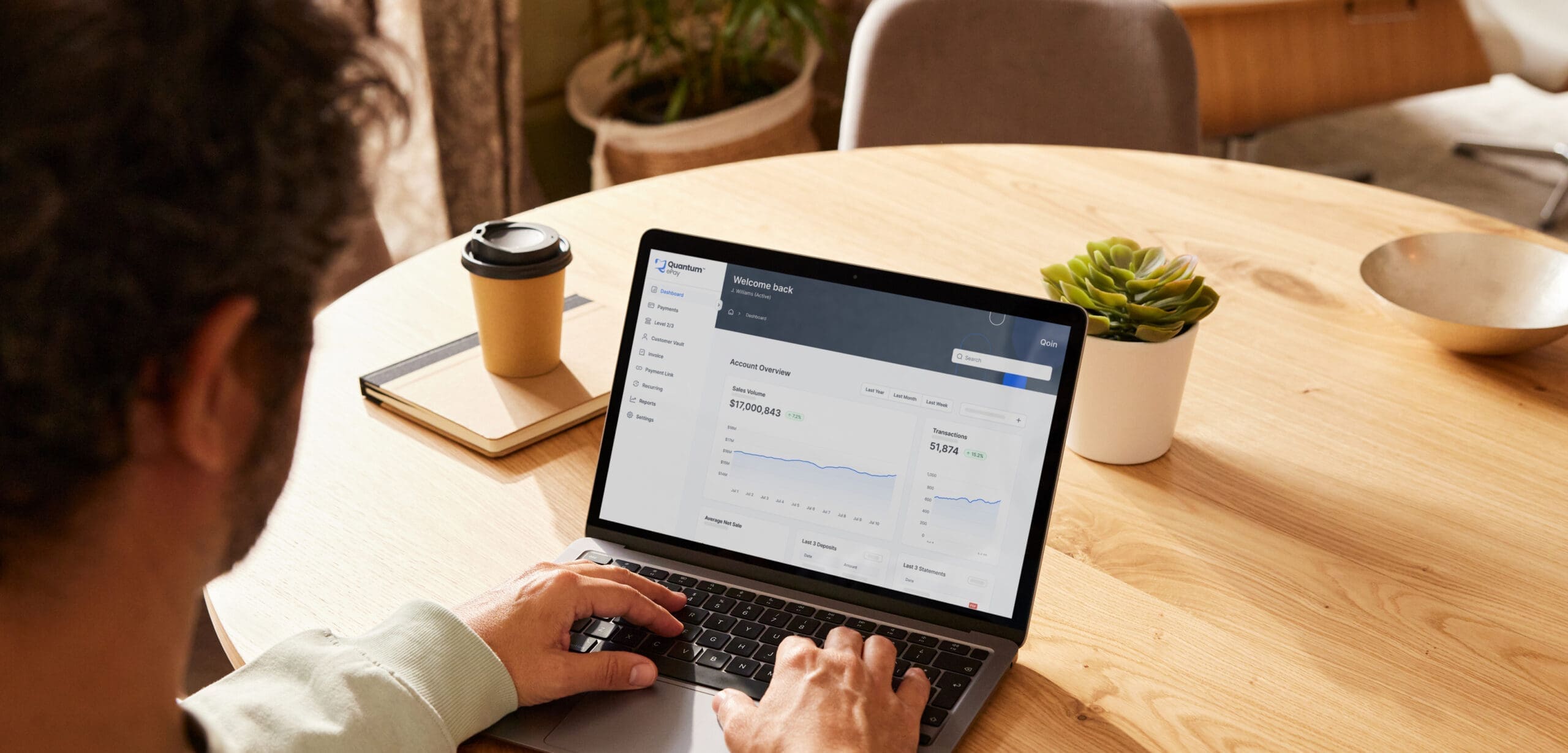 Person on laptop with Qoin dashboard on screen