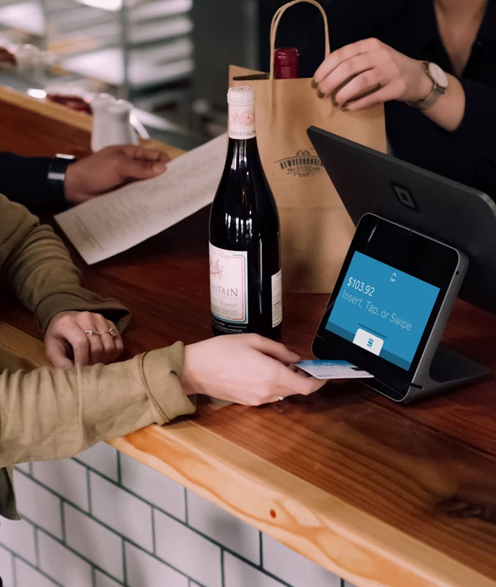 Customer paying at bar counter using card reader