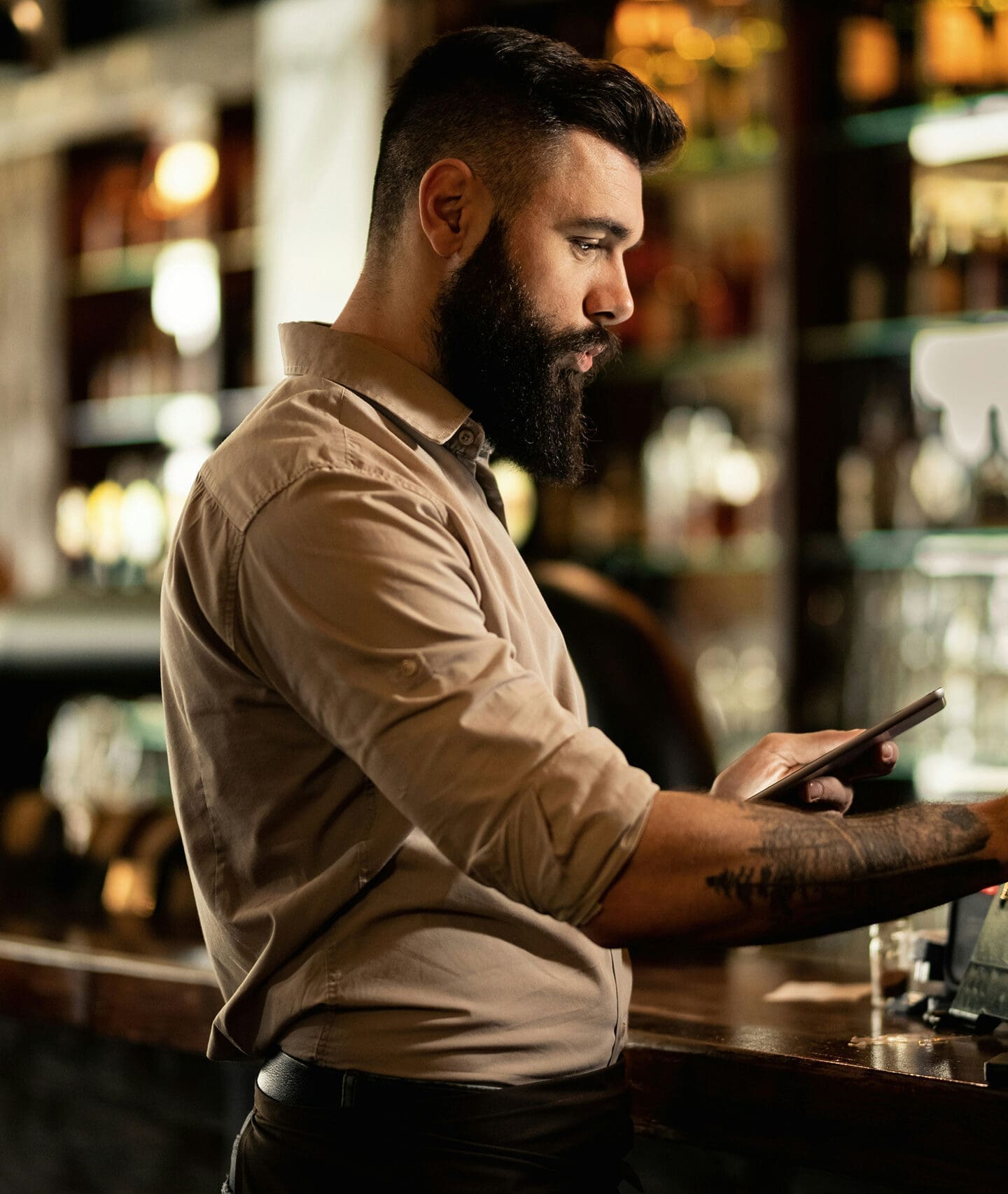 merchant using tablet behind store counter