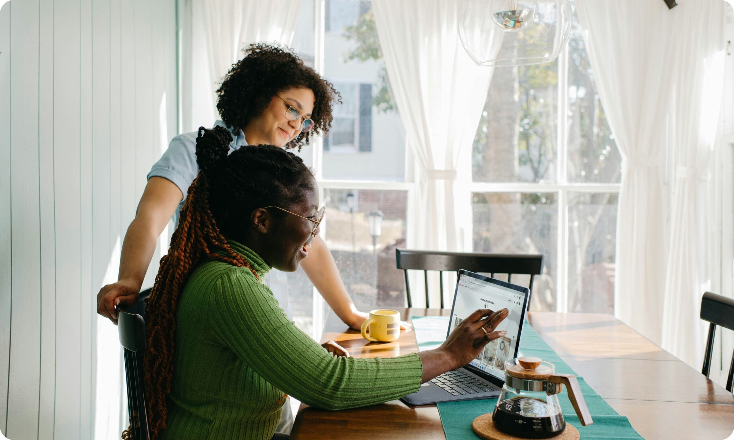 People on laptop at kitchen table