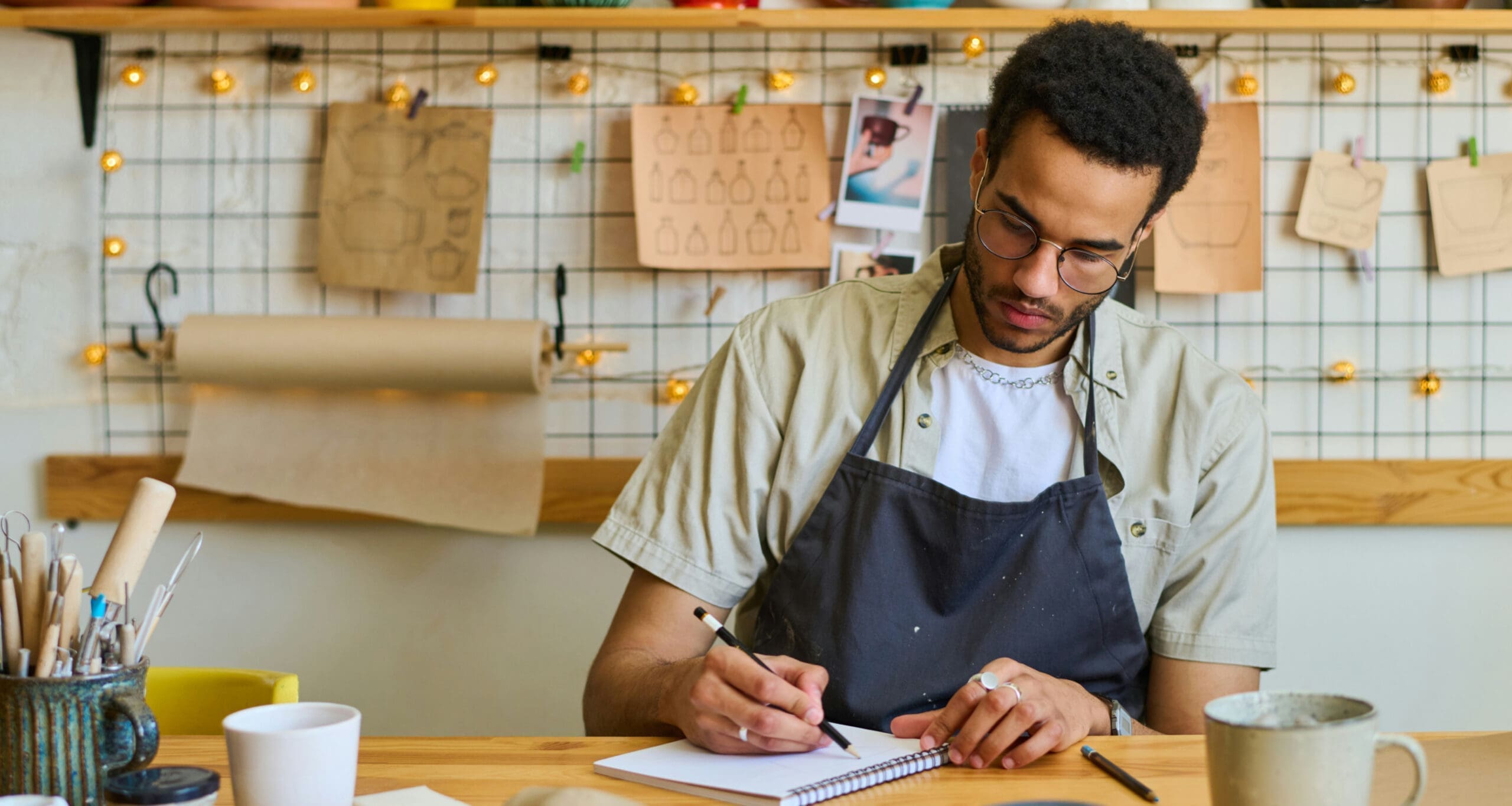 Business owner writing notes at workbench