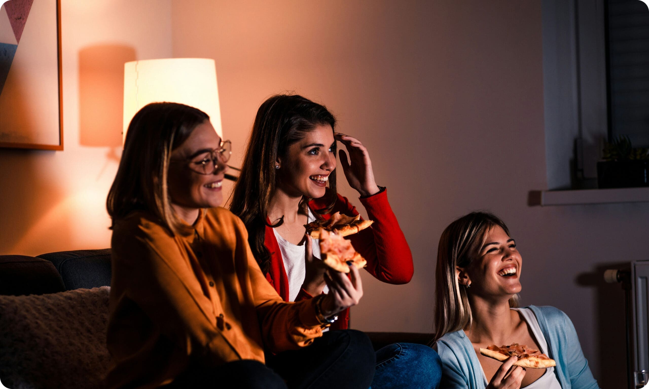 People laughing and eating pizza