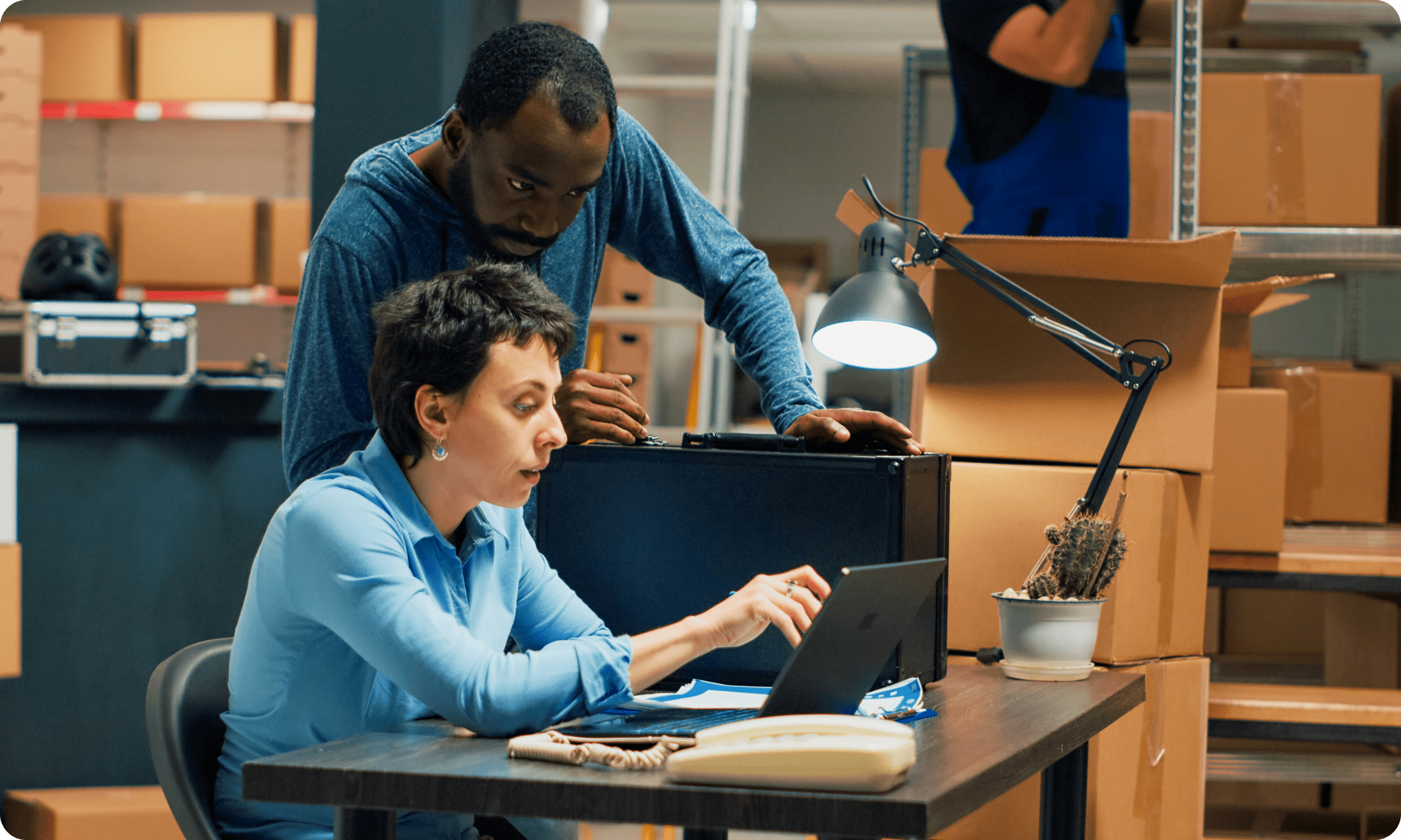Warehouse staff reviewing information on laptop